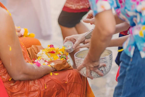 Personer hälla vatten till buddhistmunk och ger välsignelse — Stockfoto