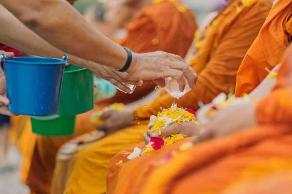 Άνθρωποι που ρίχνει νερό να βουδιστής μοναχός και δίνει ευλογία — Φωτογραφία Αρχείου