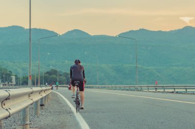 Tay kadın gün batımı sonra akşam egzersiz için bisiklet binmek