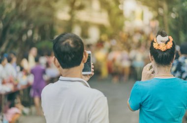 İnsanların arka görünümü bir Tay dans geçit akıllı telefon ile bir fotoğraf çekmek