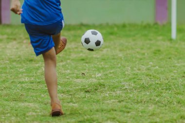 Asyalı erkek kamu futbol alanında gol topu tekme uygulama.