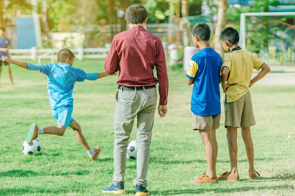 Asyalı çocuklar puan gol için topu tekme uygulama 