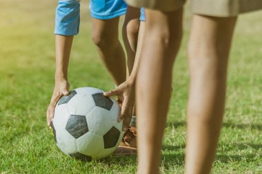 Asyalı erkek kamu futbol alanında gol topu tekme uygulama.