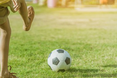 Asyalı erkek kamu futbol alanında gol topu tekme uygulama.