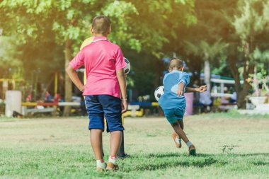 Asyalı erkek kamu futbol alanında gol topu tekme uygulama.