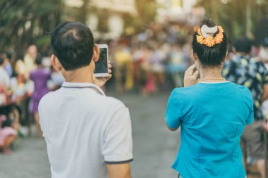 İnsanların arka görünümü Songkran festivalinde bir Tay dans geçit akıllı telefon ile bir fotoğraf çekmek