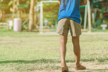 Asyalı erkek kamu futbol alanında gol topu tekme uygulama.