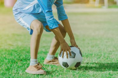 Asyalı erkek kamu futbol alanında gol topu tekme uygulama.