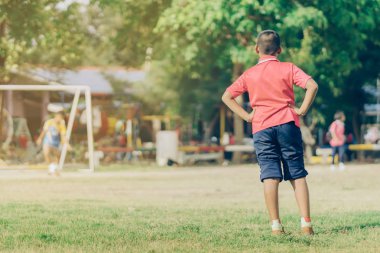 Asyalı erkek kamu futbol alanında gol topu tekme uygulama.
