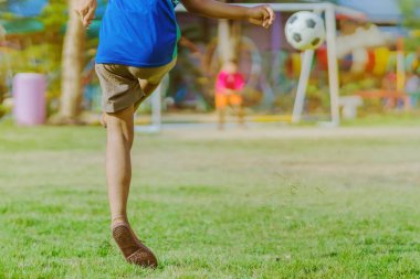 Asyalı erkek kamu futbol alanında gol topu tekme uygulama.