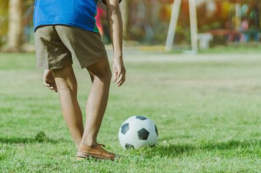 Asyalı erkek kamu futbol alanında gol topu tekme uygulama.