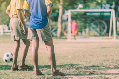 Asyalı erkek kamu futbol alanında gol topu tekme uygulama.