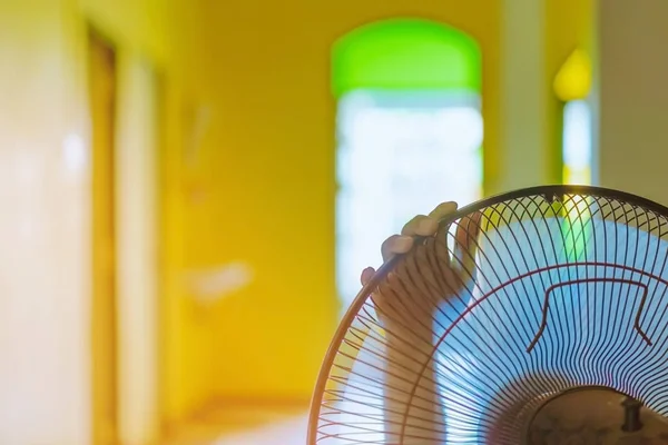 Mano de Joven tocar y ajustar en las parrillas delanteras de ventilador eléctrico para un buen viento en su casa — Foto de Stock