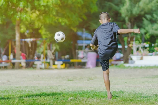 Азиатские мальчики практикуются пинать мяч, чтобы забить голы — стоковое фото