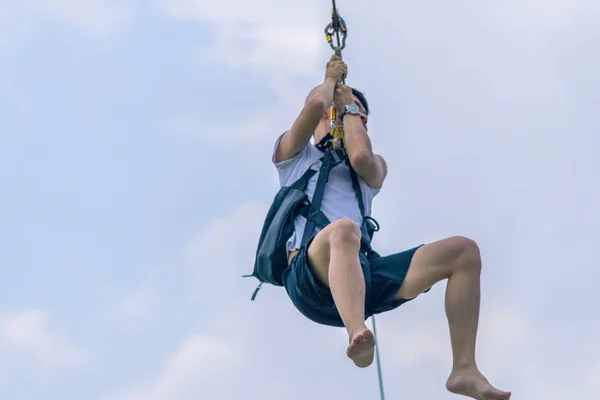 Een mannelijke toerist vliegen op een Zipline aka Flying Fox over het meer — Stockfoto