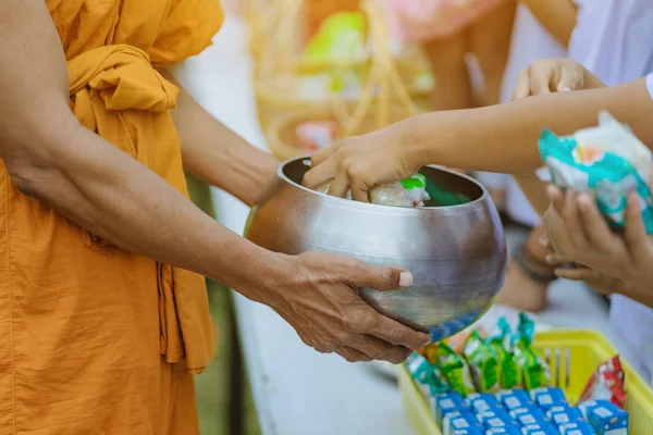 Maestros y estudiantes juntos hacen mérito para dar ofrendas de comida a un monje budista — Foto de Stock