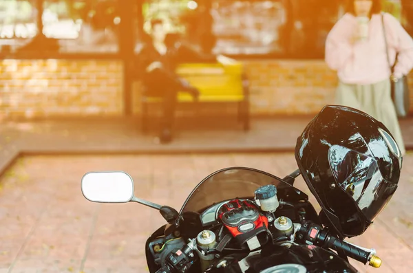A sporty motorcycle parked in front of a coffee shop — Stock Photo, Image