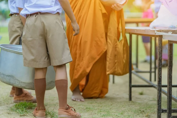 Maestros y estudiantes juntos hacen mérito para dar ofrendas de comida a un monje budista — Foto de Stock