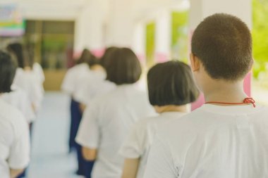 Bir grup öğrenci okulda Budist rahiple yürüyerek huzur için meditasyon yapmaya çalışıyor.