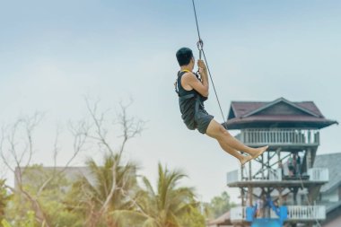 Bir zipline aka göl boyunca uçan tilki uçan bir erkek turist