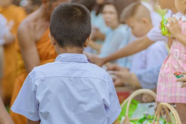 Öğretmenler ve öğrenciler birlikte bir Budist keşiş için gıda teklifleri vermek için hak yapmak 