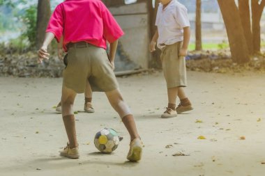 Öğrenci okulda yerde arkadaşları ile eski futbol oynamak için zevk.