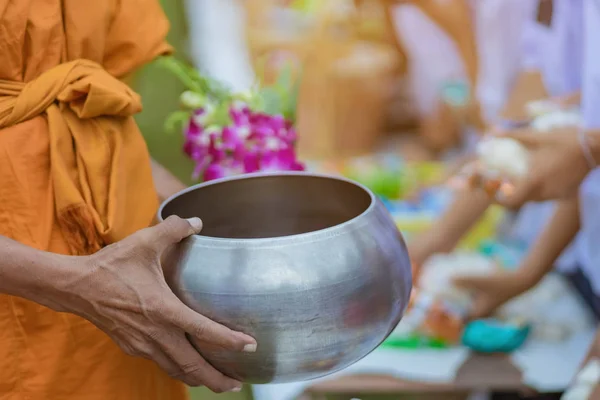 教师和学生一起为在重要的宗教日向佛教僧侣提供食物献祭立 — 图库照片