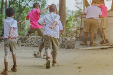 Öğrenci okulda yerde arkadaşları ile eski futbol oynamak için zevk.