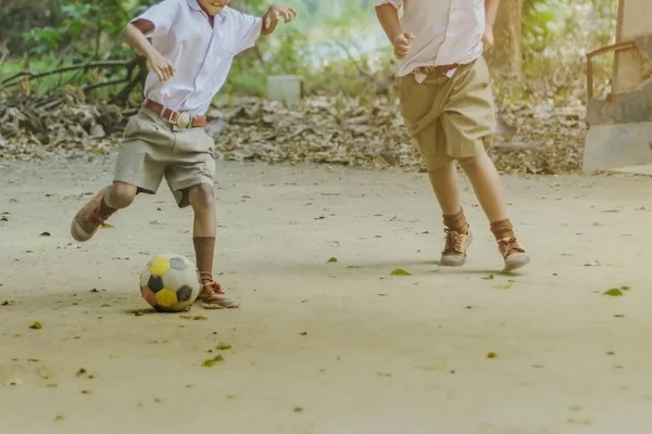 Öğrenci okulda yerde arkadaşları ile eski futbol oynamak için zevk.