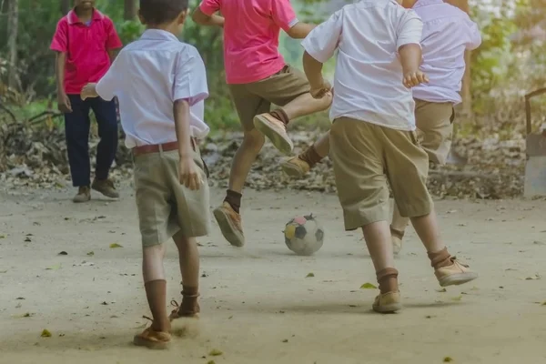 Estudiante disfrutar de jugar el viejo fútbol con sus amigos — Foto de Stock