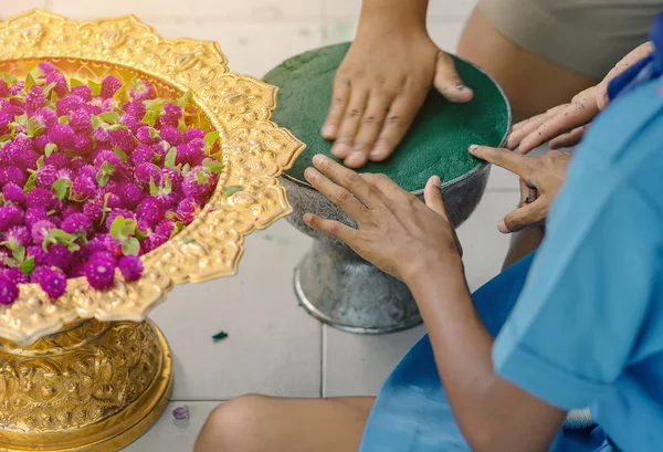Students help each other to create a flowers tray with pedestal for Teacher