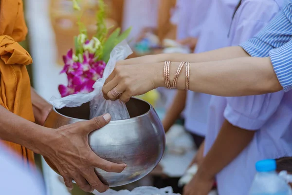 Enseignants et étudiants font ensemble le mérite de donner des offrandes alimentaires à un moine bouddhiste — Photo