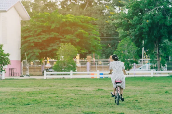 Rückansicht einer Lehrerin fährt Fahrrad, um Schüler zu unterrichten — Stockfoto