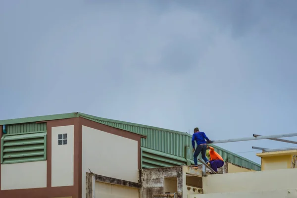 Worker welding the steel part for roof  before it is going to rain. — Stock Photo, Image