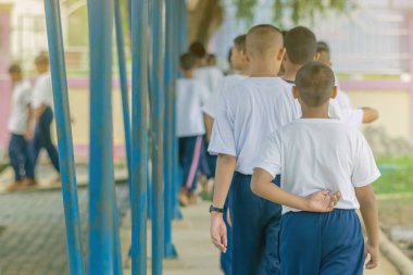 Bir grup öğrenci Budist keşişle yürüyerek huzur için meditasyon yapmaya çalışıyor.