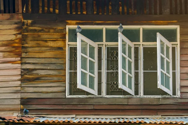 Palomas en la vieja ventana de madera de la antigua casa de madera. —  Fotos de Stock