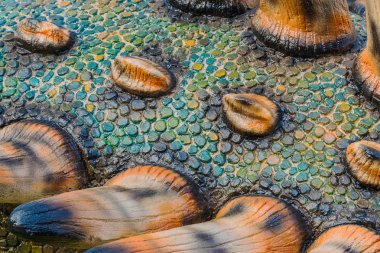 Renkli ve dinazor modelinin desenleri çimentoyla yaratılmış.