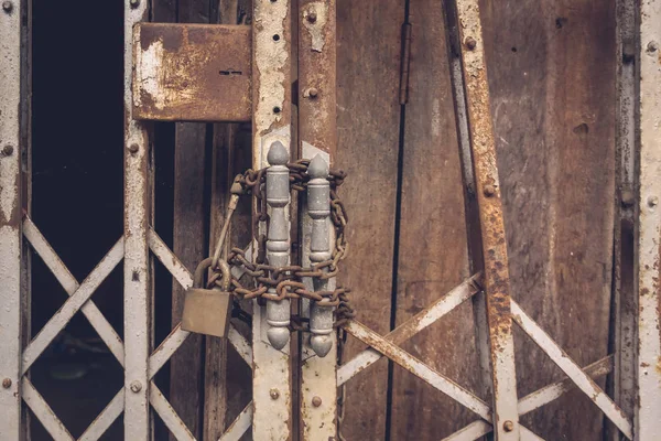 La vue de face vieille serrure en acier doré et endommagé et rouillé porte en acier sur fond de porte en bois — Photo