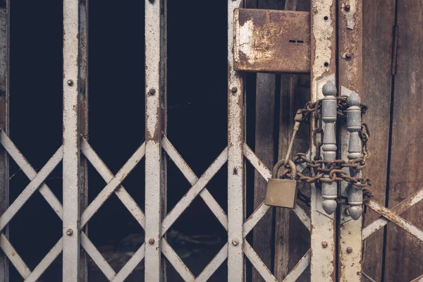 A vista frontal bloqueio de aço ouro velho e porta de aço danificado e enferrujado no fundo da porta de madeira — Fotografia de Stock