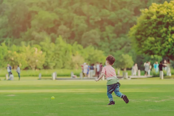 Kid gosta de jogar com pouca bola no campo verde — Fotografia de Stock