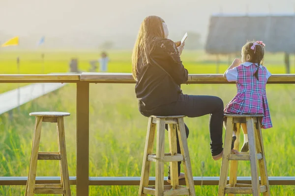 Mamma och dotter sitta för vila och väntar på tid att ta bilder av solnedgången — Stockfoto