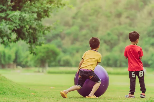 Kanchanaburi thailand - 22. april: unbekannte kinder entspannen mit großem ball auf der grünen wiese — Stockfoto