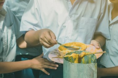 Öğrenciler Budist Lent günü için tapınağa erime dökme mum teklif katılmak,