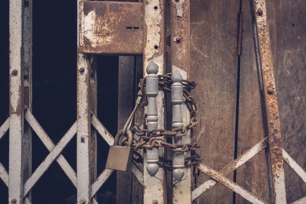 La vue de face vieille serrure en acier doré et endommagé et rouillé porte en acier sur fond de porte en bois — Photo
