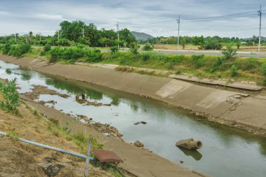 Beton duvardaki sulama kanalı ya da sulama kanalı çiftçinin tarımsal alanına su gönderin.