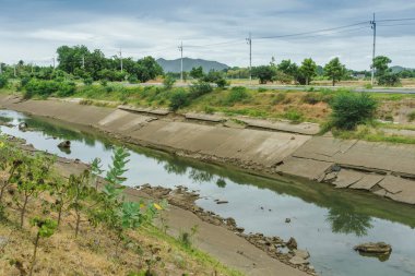Beton duvardaki sulama kanalı ya da sulama kanalı çiftçinin tarımsal alanına su gönderin.
