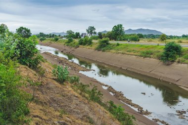 Beton duvardaki sulama kanalı ya da sulama kanalı çiftçinin tarımsal alanına su gönderin.