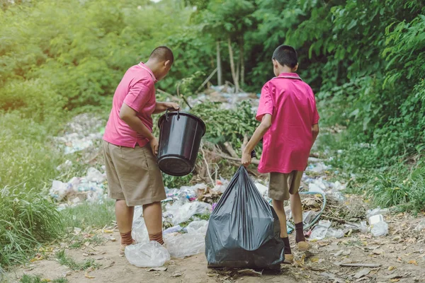 Estudiantes masculinos ayudan a eliminar la basura del aula para amontonar residuos . — Foto de Stock