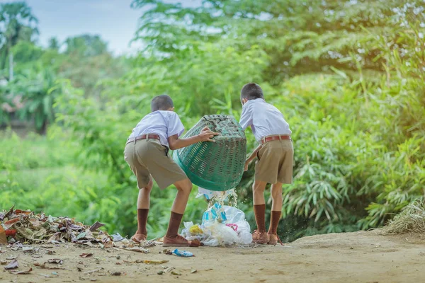 Estudiantes masculinos ayudan a eliminar la basura del aula para amontonar residuos . — Foto de Stock