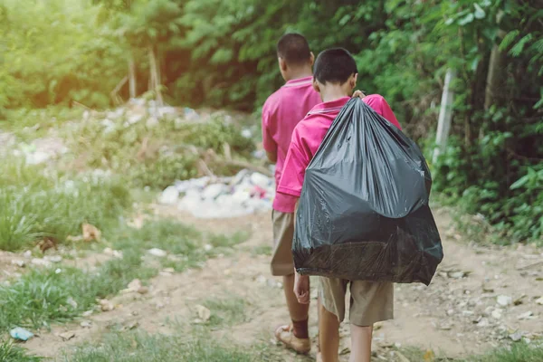 Estudiantes masculinos ayudan a eliminar la basura del aula para amontonar residuos . — Foto de Stock